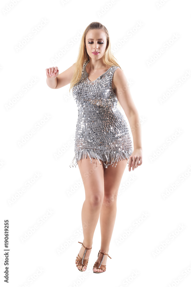 Fototapeta premium Attractive passionate party girl dancing in glittering metallic silver dress. Full body length portrait isolated on white studio background. 