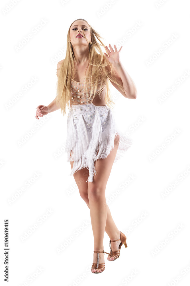 Backlit woman dancing latino dances in fringed costume dress with tousled hair. Full body length portrait isolated on white studio background. Backlit woman dancing latino dances in fringed costume dress with tousled hair. Full body length portrait isolated on white studio background.