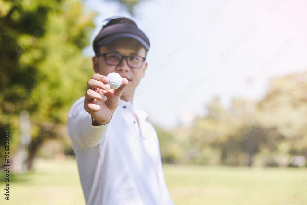 Asian men playing golf. men showing golf ball in hand standing on field Asian men playing golf. men showing golf ball in hand standing on field