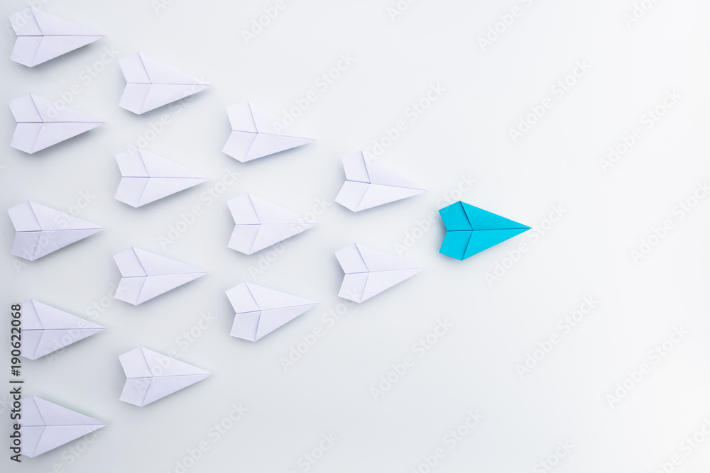 Leadership concept with blue paper plane leading among white. Leadership concept with blue paper plane leading among white.