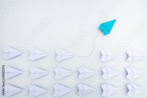 Group of paper planes in one direction and with one individual pointing in the different way. Business concept for innovative solution. photo
