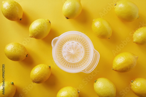 Принти на полотні Lemons with lemon squeezer against a yellow background