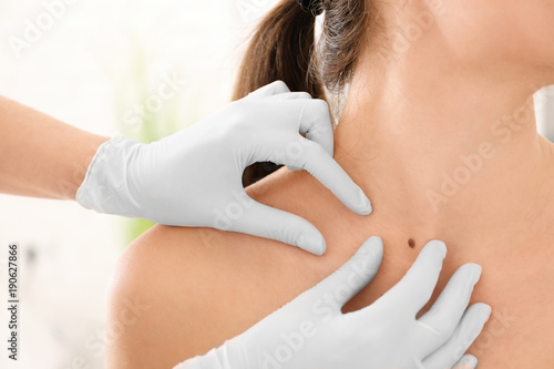 Photos Oncologist examining female patient in clinic. Cancer awareness