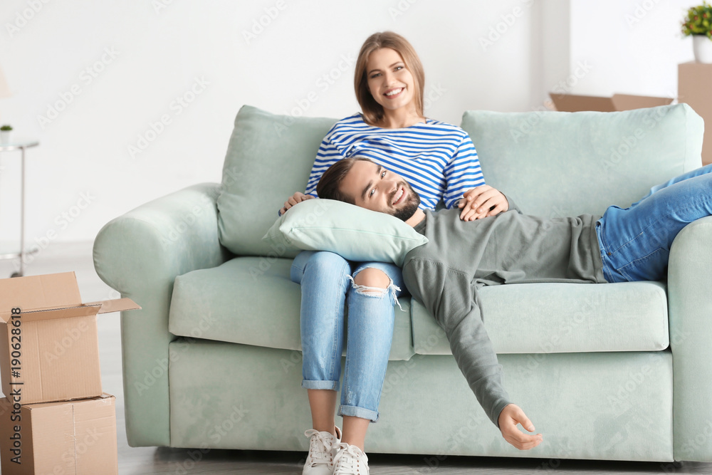 Young couple resting on sofa after moving to new home Young couple resting on sofa after moving to new home