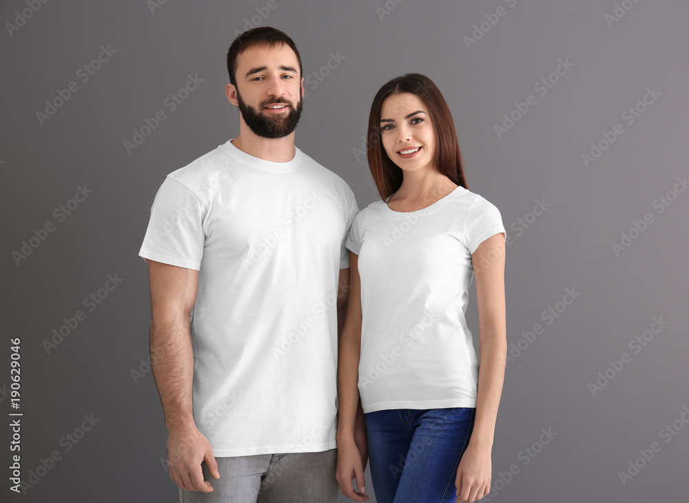 Φωτογραφία Young man and woman in stylish white t-shirts on grey background