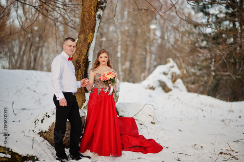 Amazing couple in winter fairytale forest in love. Girl in red beautiful dress. Valentine's Day theme. © AS Photo Family