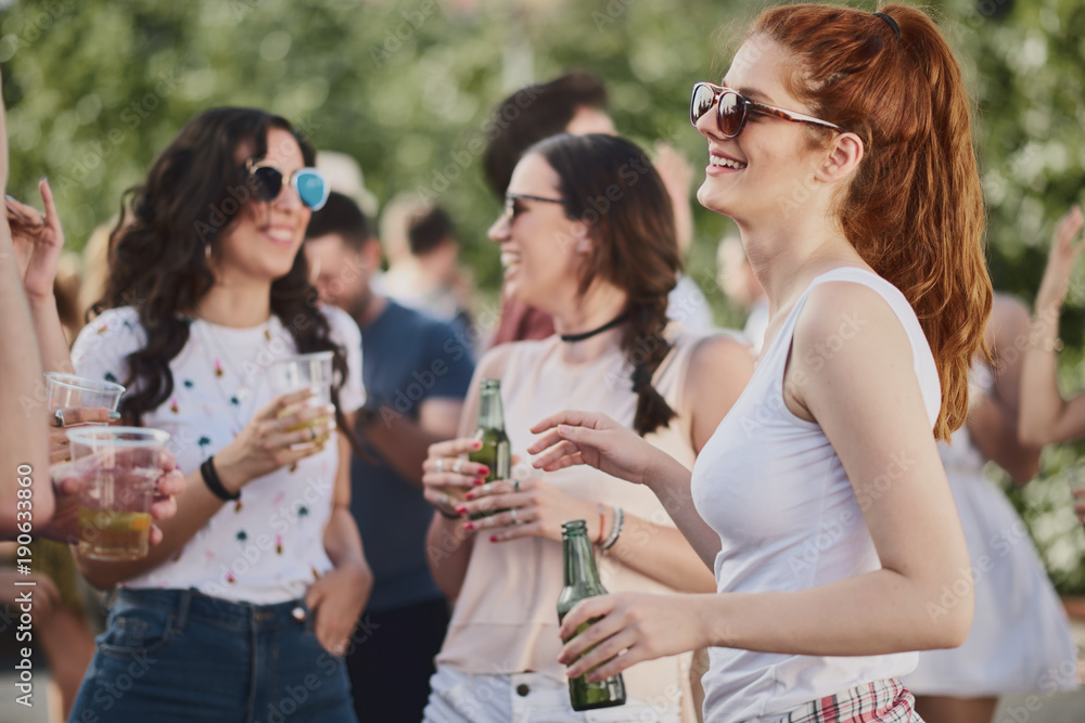 Group of people standing and drinking at the summer outdoor party Group of people standing and drinking at the summer outdoor party