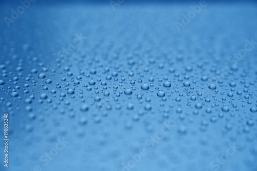 Clear water drops on blue background. Shallow depth of field.