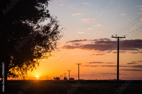 Beautiful sunste in the fileds aof Argentina with electric poles going to the horizon