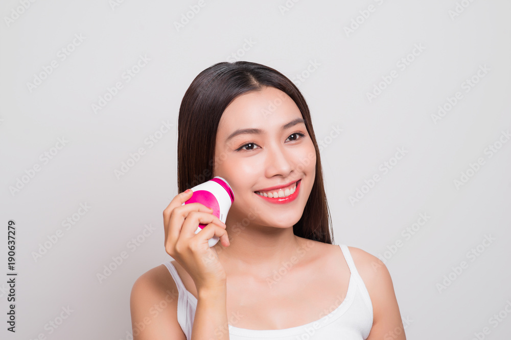 Young asian woman uses an electric brush for deeply clean Young asian woman uses an electric brush for deeply clean