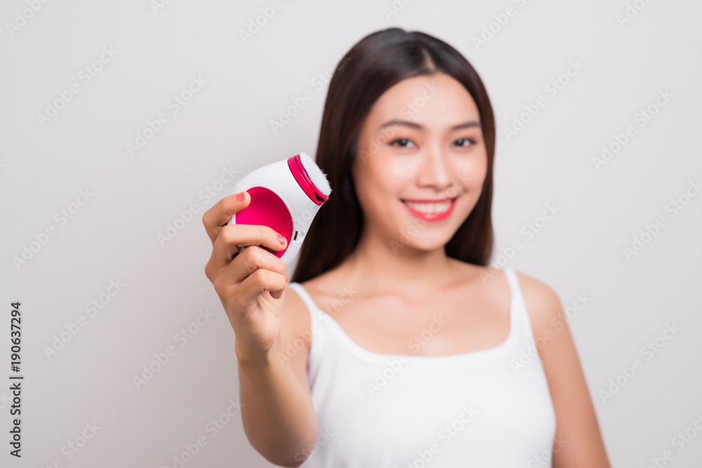 Young asian woman uses an electric brush for deeply clean Young asian woman uses an electric brush for deeply clean