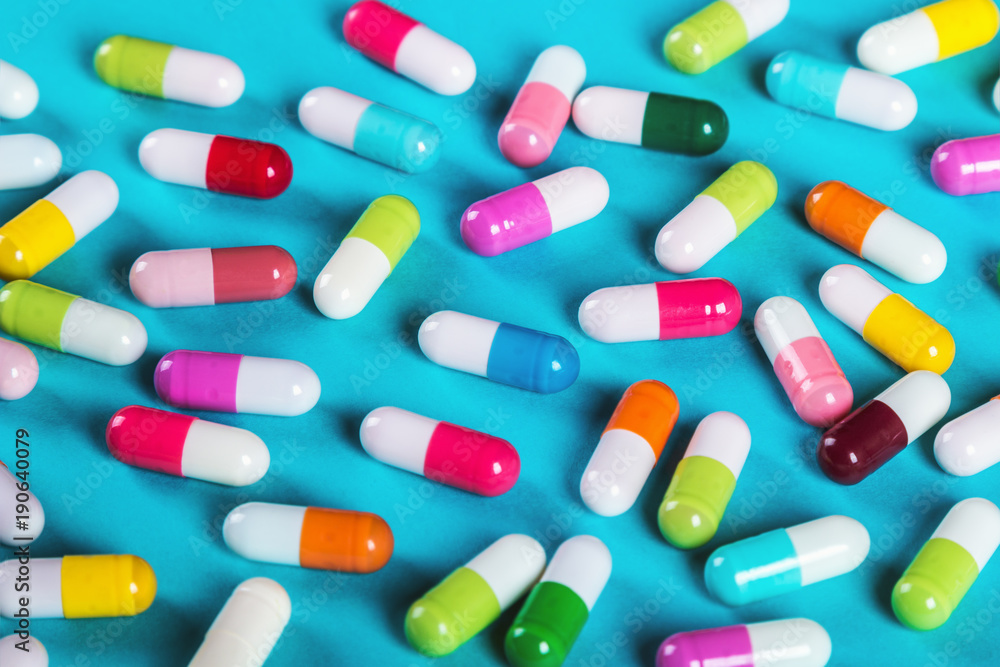 different color pills on blue background. Drugs and medicines different color pills on blue background. Drugs and medicines