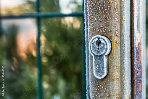 Gate with a lock covered with the first frost.