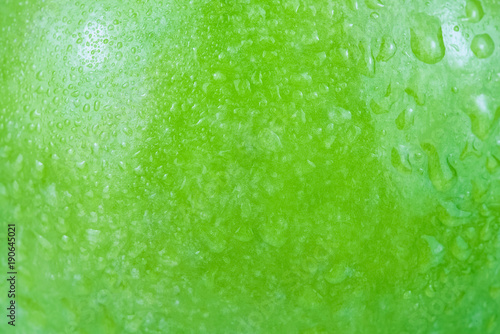 фотографія Water drops background on a green apple surface in close-up