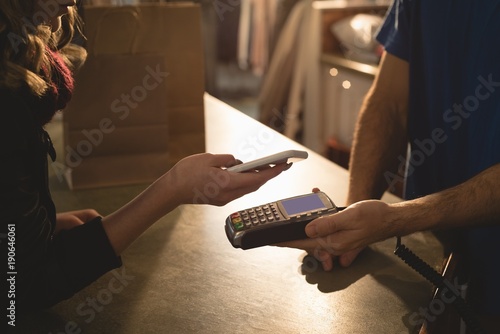 Woman making payment through mobile phone photo
