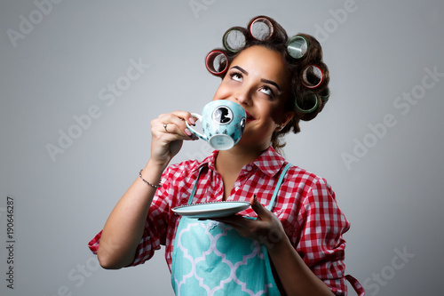 Girl housewife drinks tea from a cup.
