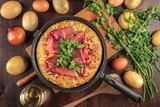 Spanish tortilla with wine and ingredients on dark texture