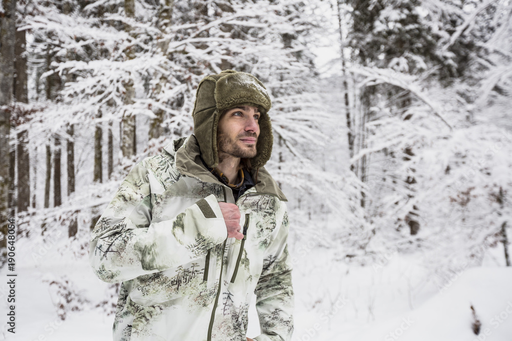 Man in camouflage jacket in winter forest Man in camouflage jacket in winter forest