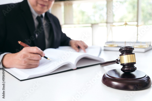 Close up of gavel, Male lawyer or judge working with Law books, report the case on table in modern office, Law and justice concept