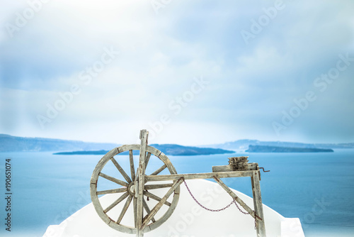 Wooden old wheel with blue sea in the background. Place for text. 