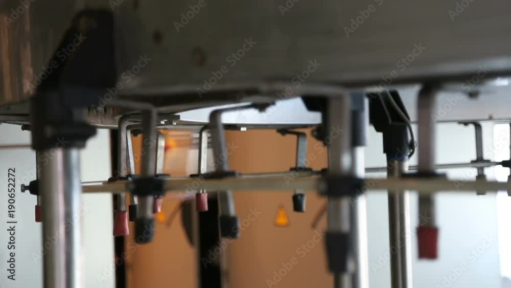 Plastic bottles in production line. Plastic bottles before blowing. Close up of production line of pet bottles. Plastic bottles in production line. Plastic bottles before blowing. Close up of production line of pet bottles.