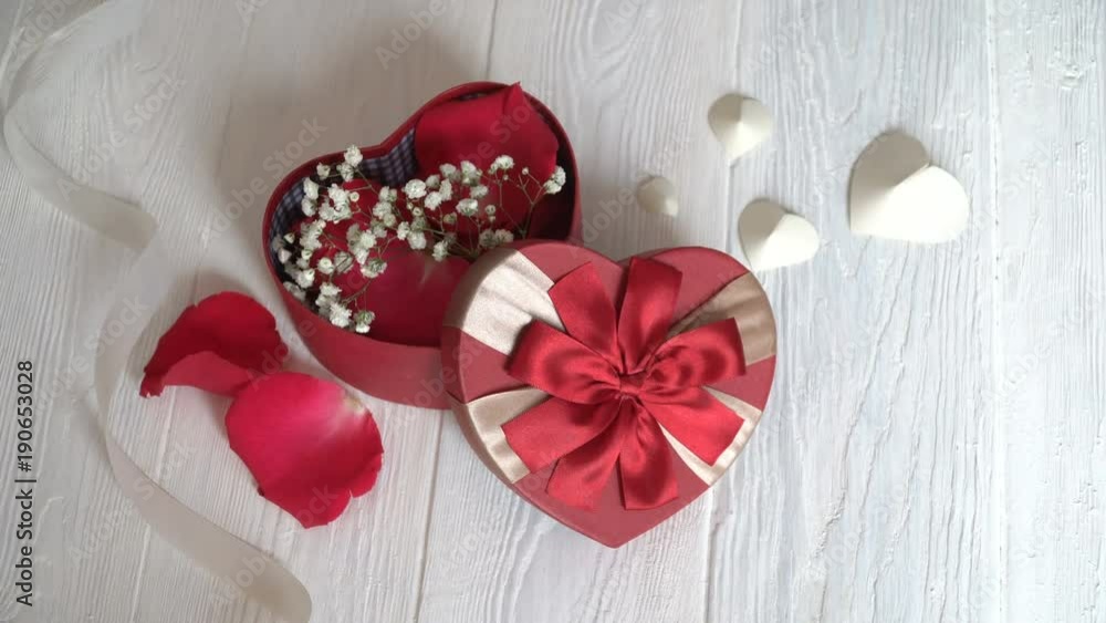 Gift box in form of heart and red ribbon on wooden white background. Top view Gift box in form of heart and red ribbon on wooden white background. Top view