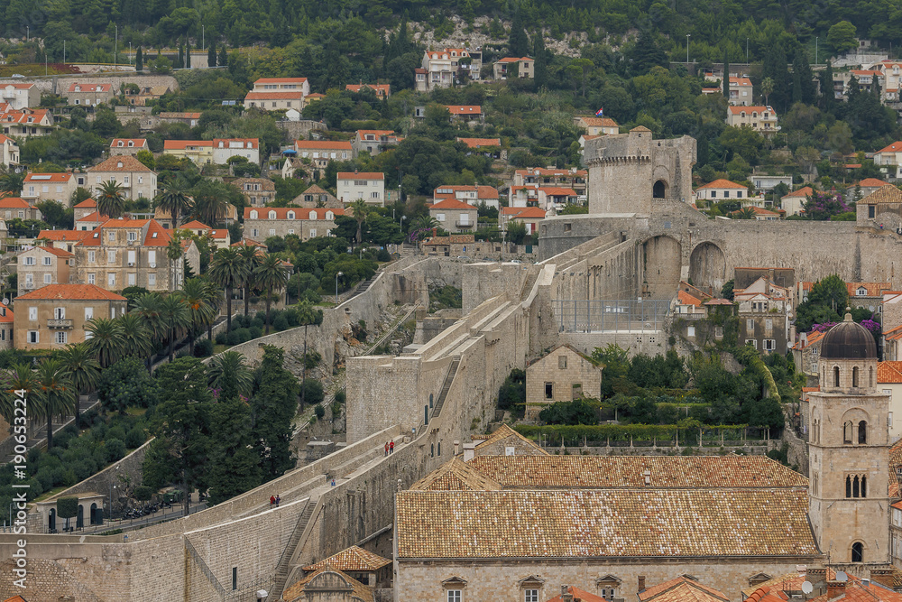 the view from the top on the fortress wall of the  Croatian city of Dubrovnik on the background of red tiled roofs