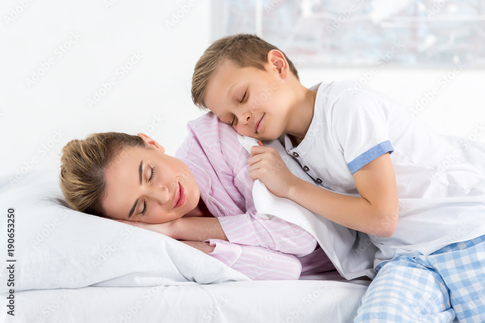 adorable little son embracing his sleeping mother adorable little son embracing his sleeping mother