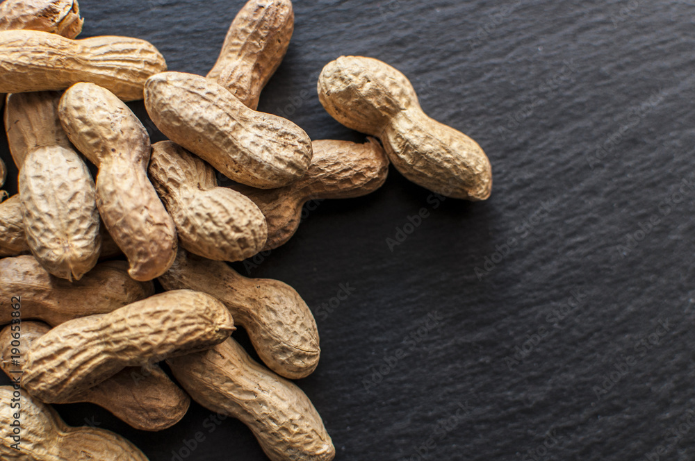 Dried peanuts in shell on black background, selective focus Dried peanuts in shell on black background, selective focus