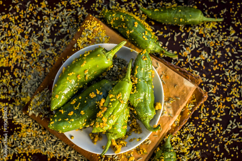 Green chilli pickle marinated in mustard seeds and mustard oil. Dark Gothic style still life concept. photo
