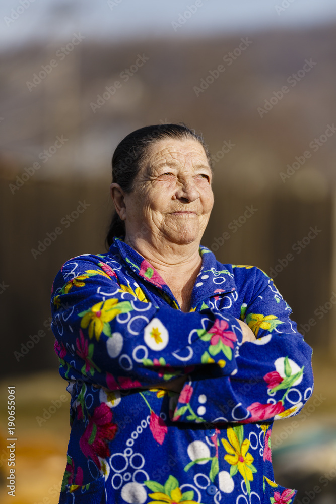 Obraz premium Old woman outdoor in her backyard, closeup portrait