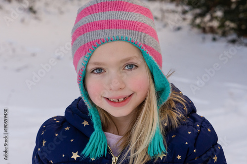 adorable school age girl playing in snow outside in winter 