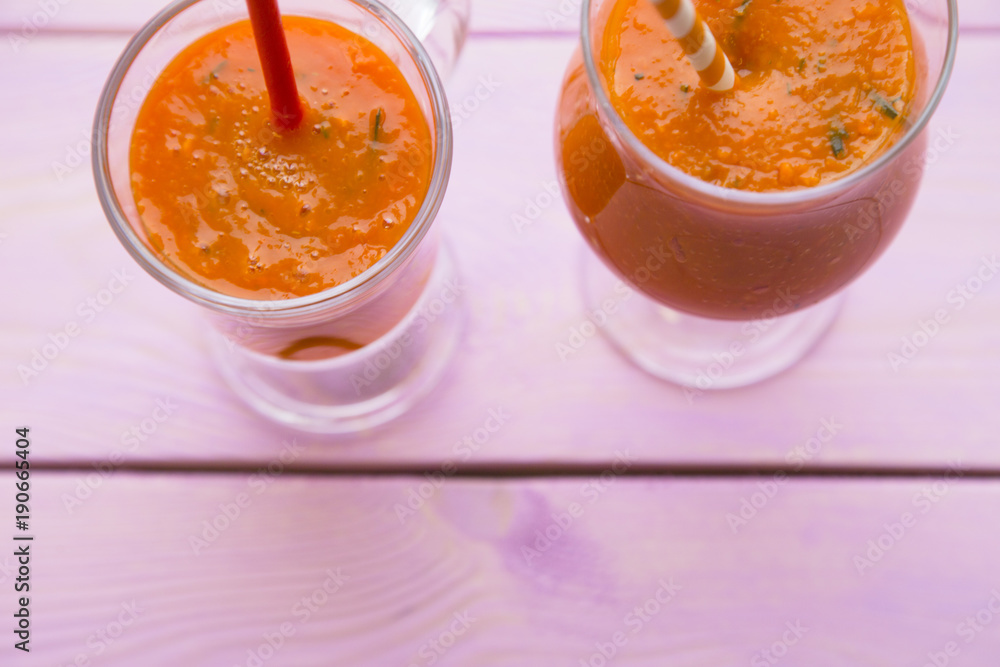 Fruit and Vegetable Smoothie, Healthy Food, Diet Concept. Two glasses of orange smoothie with carrot and pumpkin on pink wooden background Fruit and Vegetable Smoothie, Healthy Food, Diet Concept. Two glasses of orange smoothie with carrot and pumpkin on pink wooden background