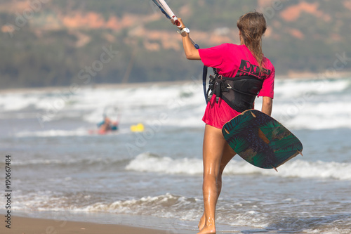 girl kite surfer walking on the beach