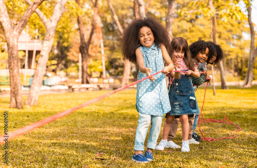 Children are happy to play tug at the park. Soft focus concept.