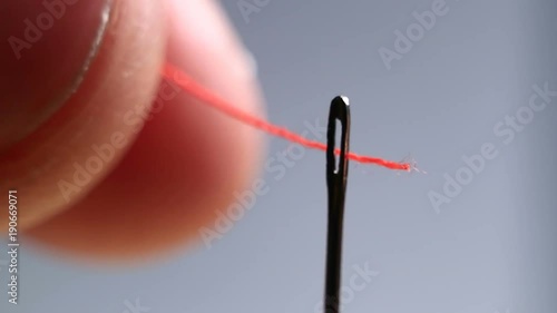 Needle with thread close-up. The designer of clothes pricked a needle. Hit the target