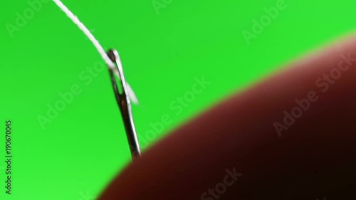 Needle with thread close-up. The designer of clothes pricked a needle. Hit the target