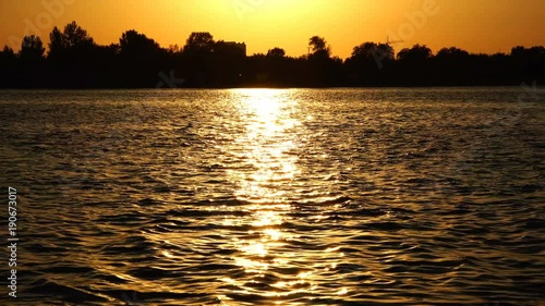 glare of the sun on the dark waters of the river photo