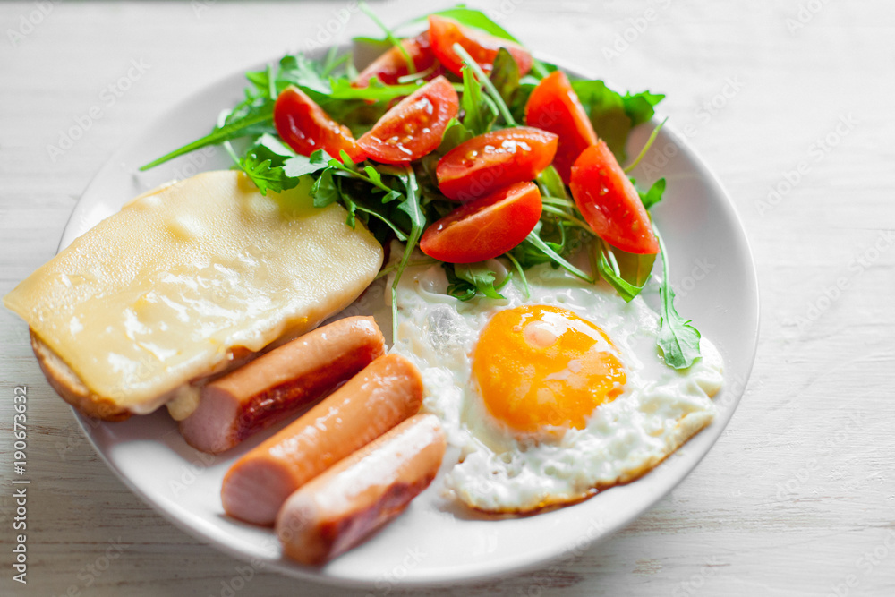 Breakfast which includes eggs, sausages, salad and toast with cheese Breakfast which includes eggs, sausages, salad and toast with cheese
