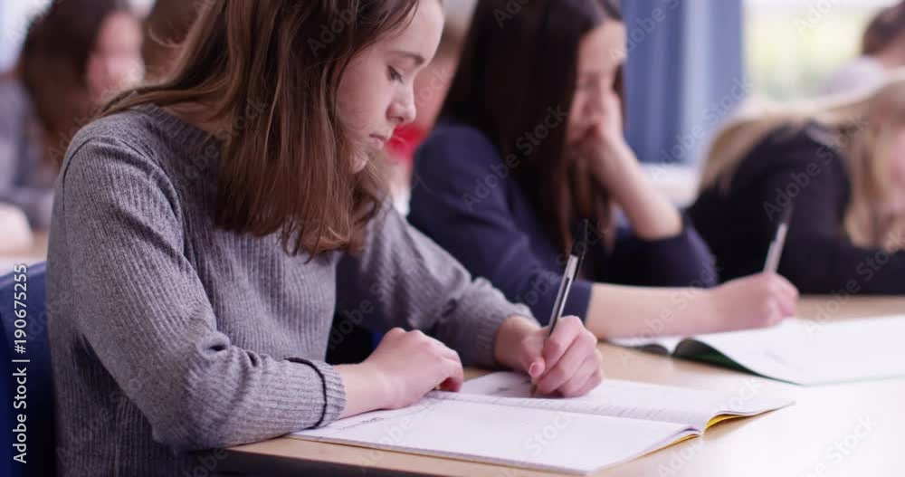 4k, Students in school uniform taking exam at desk in a classroom. Slow motion. 4k, Students in school uniform taking exam at desk in a classroom. Slow motion.