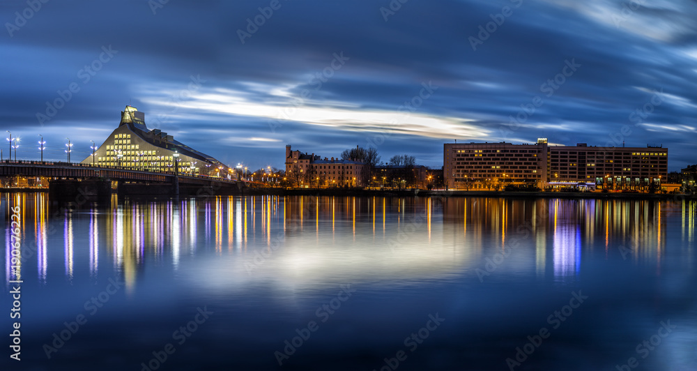 Riga skyline with National Library. Night shot with scenic water reflections in Daugava river waters