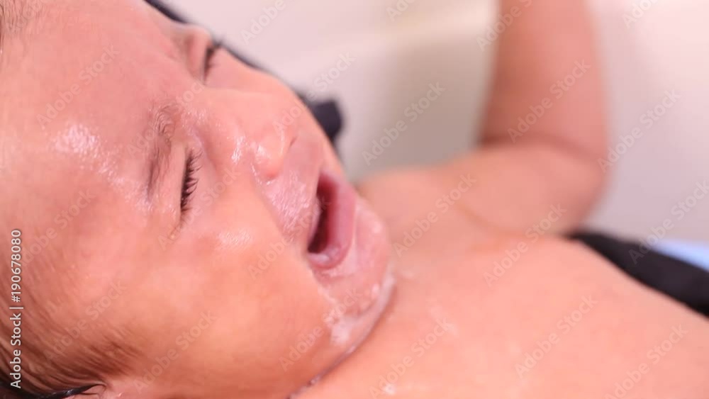 Newborn baby boy taking bath in a tub Newborn baby boy taking bath in a tub
