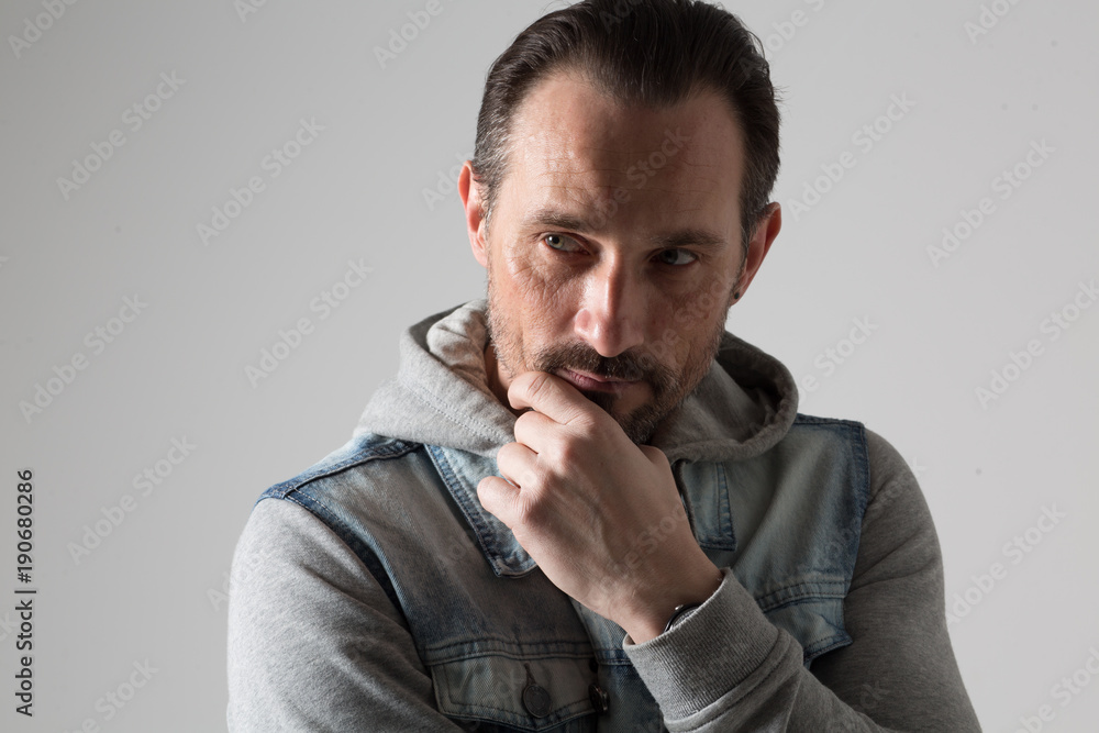 Dark haired and beard cool man looking thoughtfully and directly. Dark haired and beard cool man looking thoughtfully and directly.