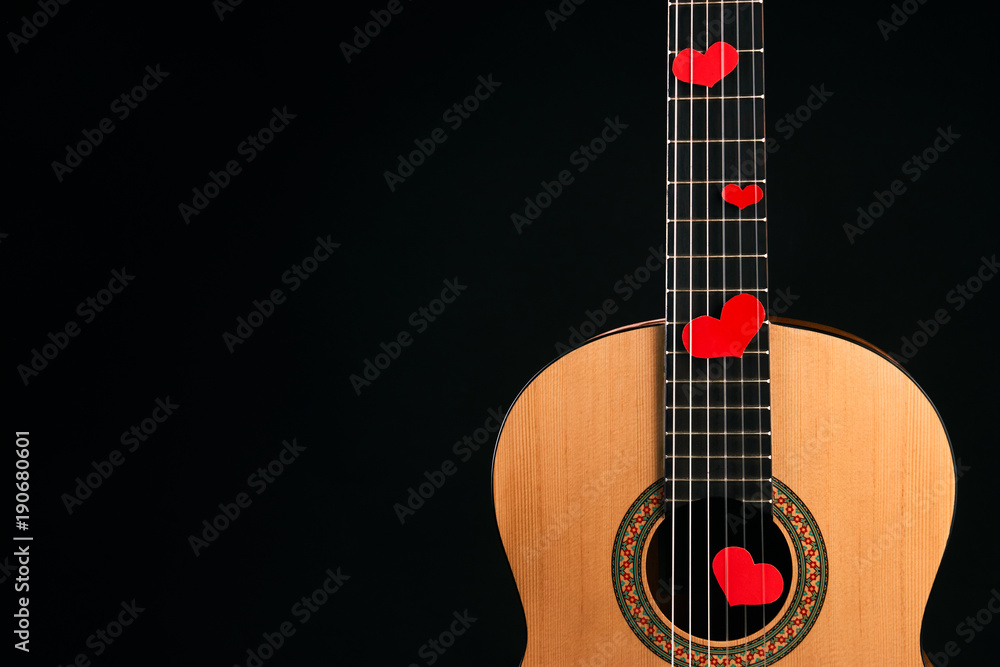 Red hearts on the strings of a guitar