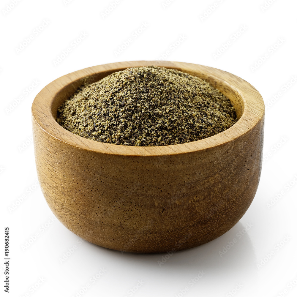 Finely ground black pepper in dark wood bowl isolated on white. Finely ground black pepper in dark wood bowl isolated on white.