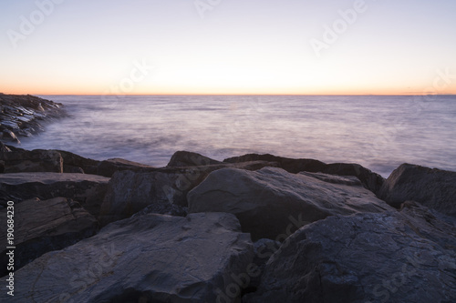 Seascape at sunrise. Waves break on the rocks at dawn.