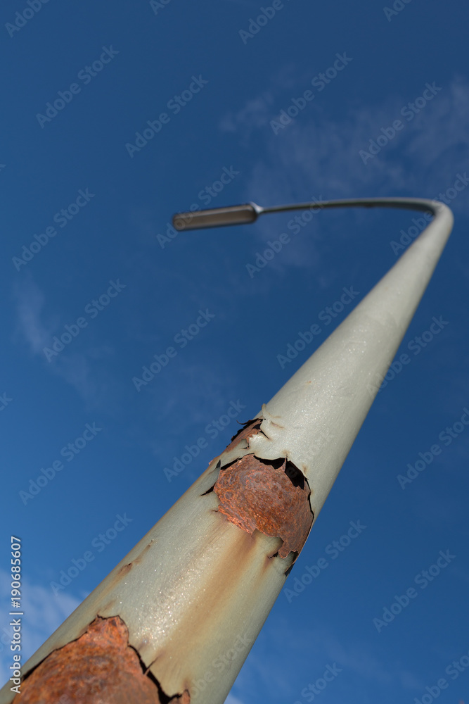 Rostige Strassenlampe ragt in den blauen Himmel Rostige Strassenlampe ragt in den blauen Himmel