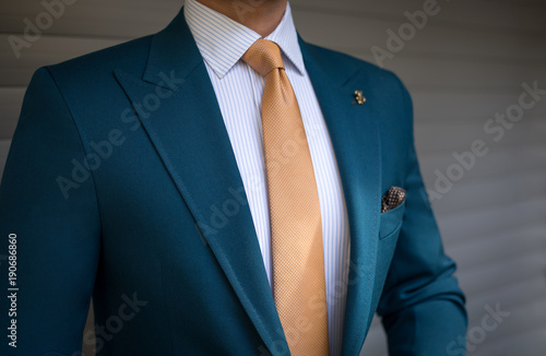 Obraz na płótnie Man in elegant custom tailored suit posing in front of background