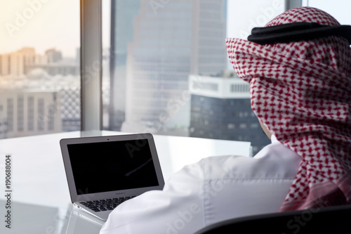 Saudi Arab Man Watching Laptop at Work Contemplating photo