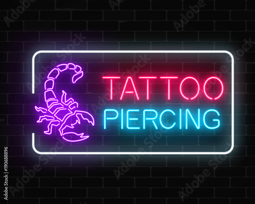 Tattoo and piercing parlor glowing neon signboard with scorpio emblem.